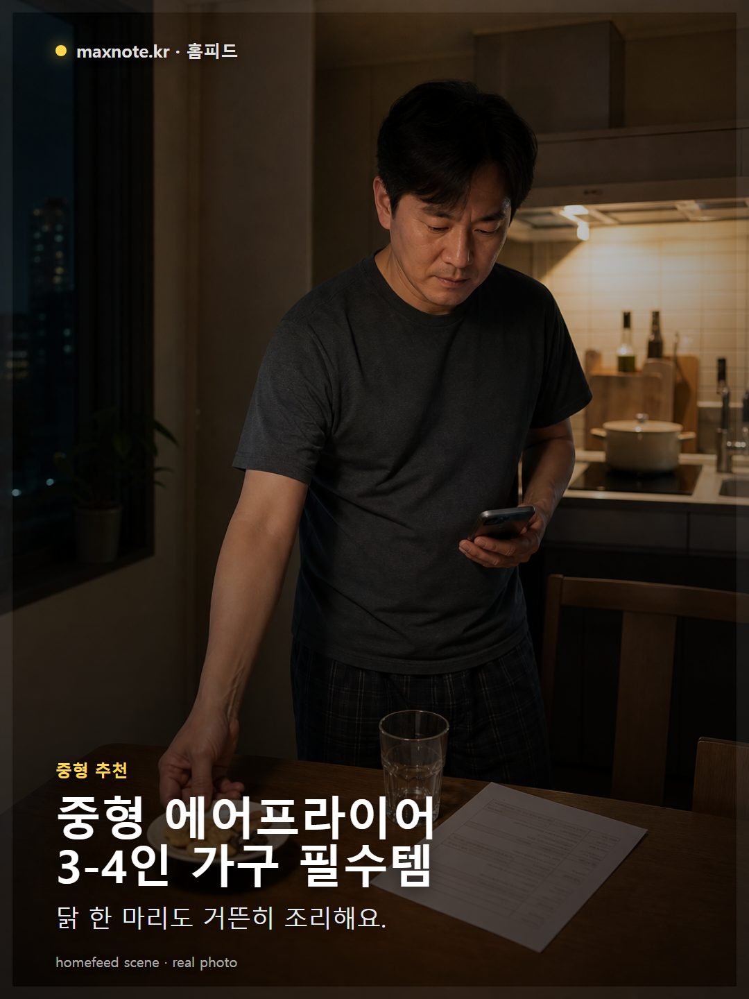 닭 한 마리가 들어있는 중형 에어프라이어 바스켓을 한국인이 주방에서 사용하는 모습